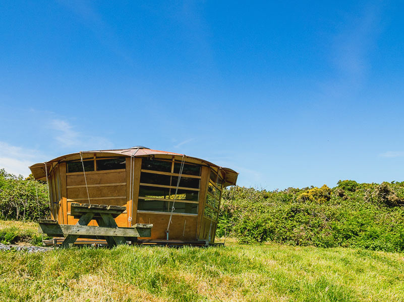 Caban with picnic bench on a green hill