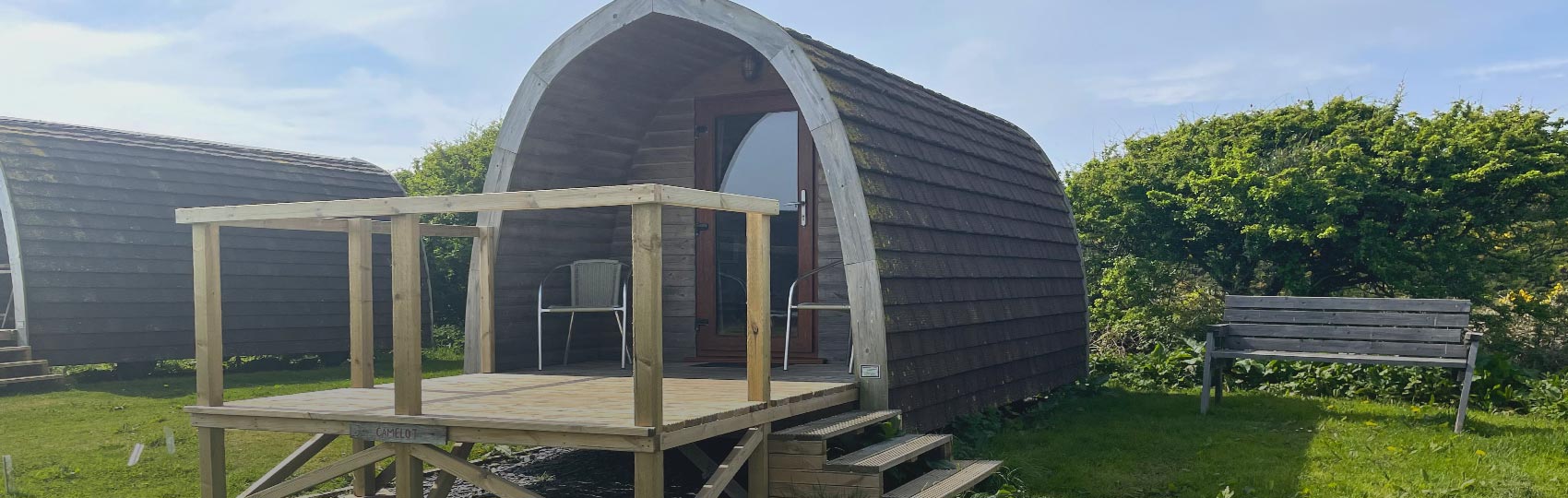 Lady relaxing in the porch of a glamping Pod on North Wales hill