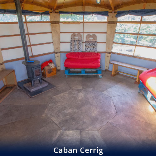 Caban Cerrig inside vide of wood burning stove and seating area