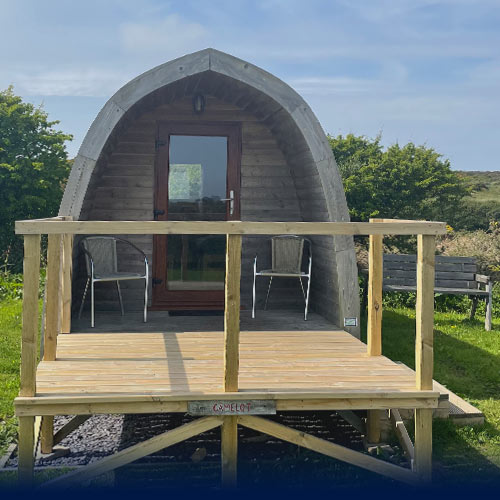 Lady and her dog relaxing in the porch of a glamping Pod